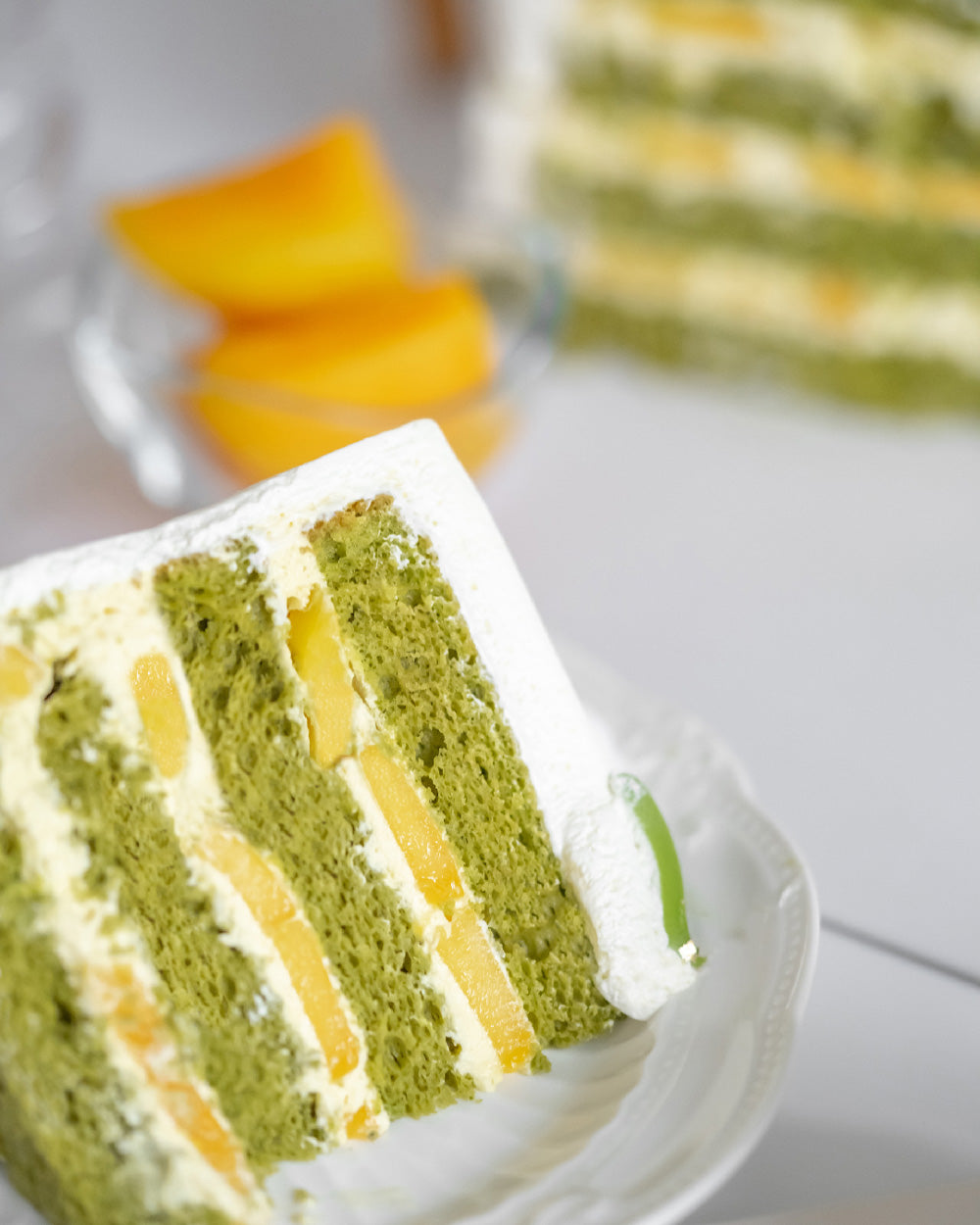 Matcha Mango Cake with matcha sponge, mango fresh cream, fresh mango slices, Chantilly cream & matcha ganache