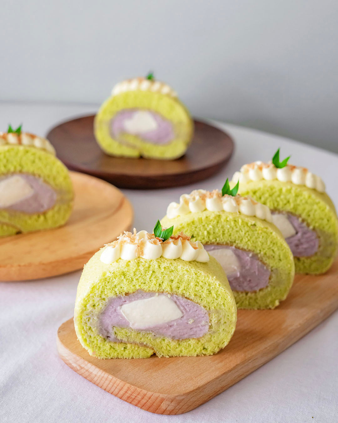Slices of Pandan swiss rolls with pure taro filling and coconut jelly centre