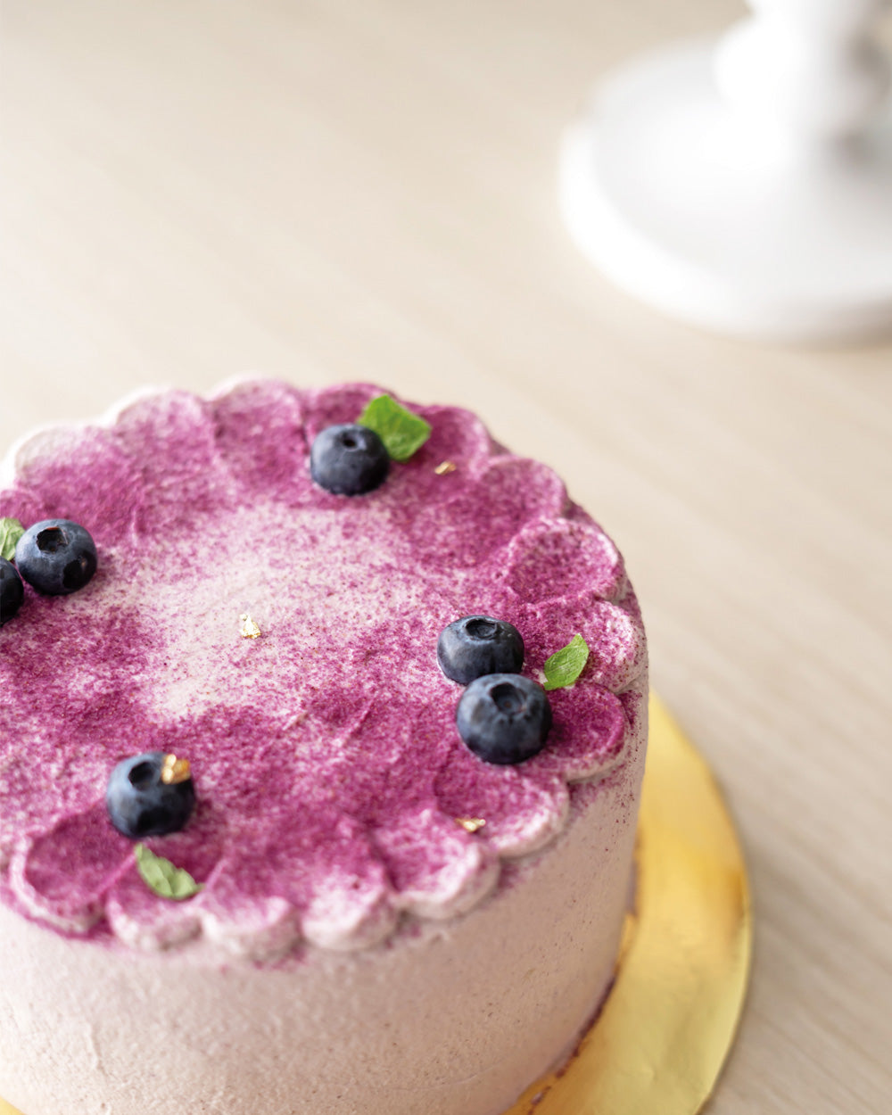 Pandan cake decorated with blueberries and mint leaves